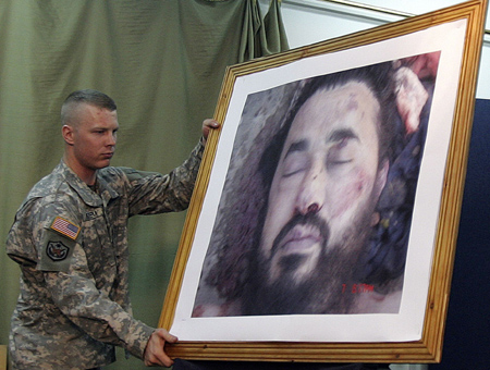 A U.S. soldier displays the picture of the dead Al Qaeda leader in Iraq, Abu Musab al-Zarqawi, during a news conference at the fortified Green Zone in Baghdad June 8, 2006. [Reuters] 