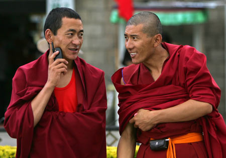 Tibetan monks use their mobile phones in Lhasa, Tibet July 3, 2006. China opened the world's highest railway on Saturday, which is expected to promote social development, economy and trade between Tibet with other parts of China. [Reuters]