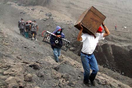 Cusua dwellers carry their belongings as they evacuate from the Tunguharua volcano, some 178 km south of Quito July 15, 2006. Ecuador's Tungurahua volcano spewed ash, gases and molten rocks on Friday, forcing authorities to evacuate four nearby villages after the crater registered its most volatile activity since a 1999 eruption. 