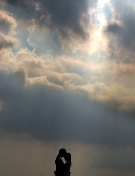 A couple stands on a riverbank in Foshan, South China's Guangdong Province May 8 2005.