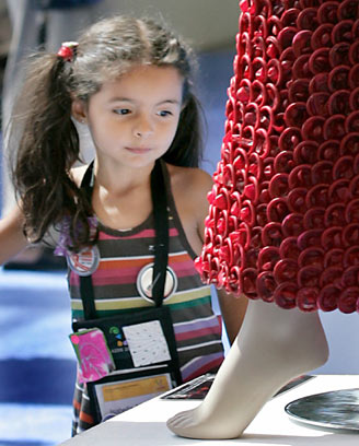 A girl looks at a dress made of condoms by Brazilian artist Adriana Bertini at the International AIDS Conference in Toronto August 17, 2006. The exhibit aims to get people comfortable about condoms, especially those living in countries where the little piece of latex is considered taboo. [Reuters] 