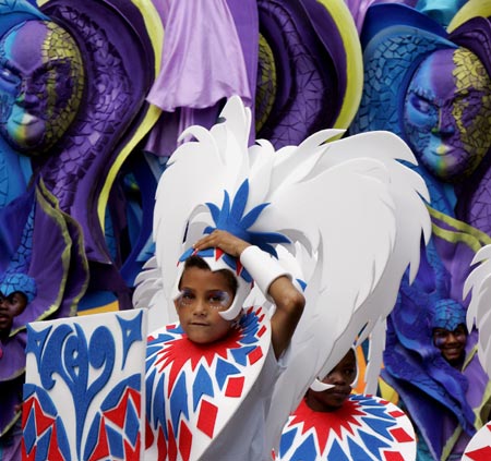 A carnival-goer adjusts his costume at the annual Notting Hill Carnival in London August 27, 2006. The carnival which began in 1964 and starts on Sunday is one of the world's largest street parties with thousands of people expected to attend over the Bank Holiday weekend.