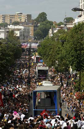 Crowds gather to watch the floats go down Ladroke Grove during children's day at Notting Hill Carnival in London, August 27, 2006. The carnival which began in 1964 and starts on Sunday is one of the world's largest street parties with thousands of people expected to attend over the Bank Holiday weekend. 