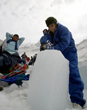 A participant in the Ruta del Hielo (Ice Route) competition carves out a block of glacial ice to carry on his back on the slopes of the Cayambe volcano, 45 kilometres north of Quito, August 27, 2006. The competitors carry blocks of glacial ice on their backs down the 5,790 meter-high volcano to the town. The annual competition evolved from the tradition of ice harvesting to make ice cream, a practice that died with the advent of electric ice-makers. 