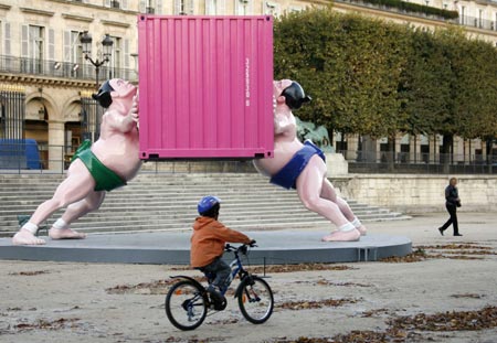 A child cycles near the statue 'It Takes Two' by artist David Mach of Scotland, which is displayed in the Tuileries Gardens in Paris October 24, 2006. The exhibit was part of the 33rd International Contemporary Art Fair (FIAC) which runs from October 26 - 30 in the French capital.