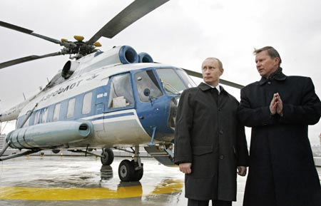 Russian President Vladimir Putin (L) and Defence Minister Sergei Ivanov stand next to a helicopter on the roof of the new GRU military intelligence headquarters building during a visit there in Moscow November 8, 2006. 