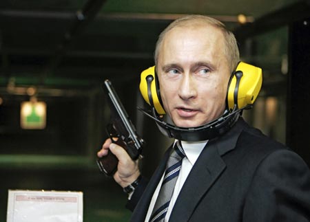 Russian President Vladimir Putin stands with a gun at a shooting gallery of the new GRU military intelligence headquarters building as he visits it in Moscow November 8, 2006.