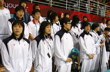 The South Korean swim team observes a minute's silence for compatriot Kim Hyung-chil before the swimming finals competition at the 15th Asian Games in Doha December 7, 2006. Kim died after falling from his horse during the games' equestrian competition on Thursday. [Reuters]