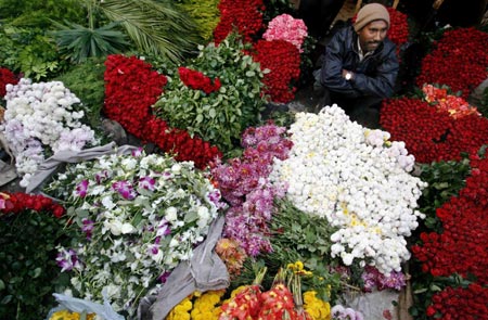 A shopkeeper waits for customers at a flower market in New Delhi December 12, 2006. 