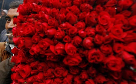 A labourer carries flowers at a flower market in New Delhi December 12, 2006. 