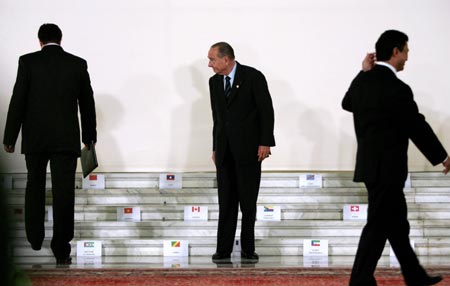 France's President Jacques Chirac (C) waits for fellow leaders to take their places during a family photo at the two-day Francophone Summit, hosted for the first time by an Eastern European country, in Bucharest September 28, 2006. 