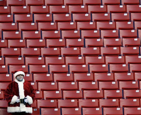 A lone fan dressed as Santa Claus remains in his seat section and watches the final minutes of the New York Giants' 30-7 loss to the New Orleans Saints in their NFL football game in East Rutherford, New Jersey December 24, 2006.