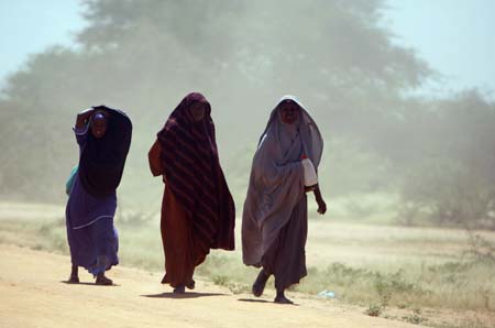 Somali refugee women walk in the dust at Ifo camp near Dadaab, about 80km (50 miles) from Liboi on the border with Somalia in north-eastern Kenya, January 8, 2007. Aid agencies are operating three large refugee camps in Dadaab where about 160,000 Somali refugees are held and said they could provide more staff to help Kenya with any new influx. 