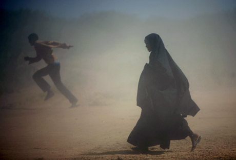 Somali refugees run from the dust at Ifo camp near Dadaab, about 80km (50 miles) from Liboi on the border with Somalia in north-eastern Kenya, January 8, 2007. Aid agencies are operating three large refugee camps in Dadaab where about 160,000 Somali refugees are held and said they could provide more staff to help Kenya with any new influx. 