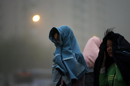 Girls walk in a sandstorm in Zhengzhou, Central China's Henan Province, March 27, 2006. [Zhang Hongfei/Dahe Newspaper] 