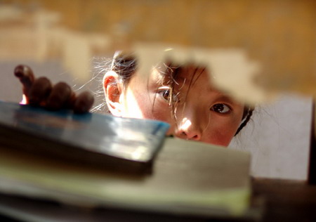 A girl takes a book from a desk at a boarding school in Guinan County, Northwest China's Qinghai Province, September 8, 2006. [Xihai Metropolis Daily]