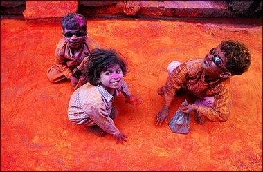 Indian children collect gulal (coloured powder) thrown on a narrow lane during the Lathmar Holi festival in Barsana, some 100 km from New Delhi. 