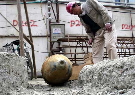 A worker inspects an unexploded bomb found at a construction site in Chengdu, capital of Southwest China's Sichuan Province, February 26, 2007. Experts thought the bomb was dropped by Japan's army in its war of aggression against China during World War II, Tianfu Morning News reported. [Tianfu Morning News reported.]