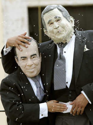 Greenpeace activists wearing masks depicting U.S. President George W. Bush (R) and Mexican President Felipe Calderon enact a 'wedding' during a protest against Bush's visit to Merida in Mexico's state of Yucatan March 12, 2007. 