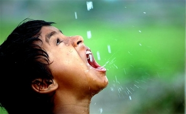 A girl quenches her thirst with water droplets from a broken pipe in the eastern Indian city of Siliguri, Thursday, March 22, 2007. World Water Day is being observed across the world Thursday. (AP Photo/Tamal Roy) 