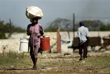 A woman carries drinking water in Port-au-Prince, Wednesday, March 21, 2007. 'Coping with Water Scarcity' is the theme for World Water Day 2007, which will be celebrated on 22 March under the leadership of the Food and Agriculture Organization of the United Nations (FAO).