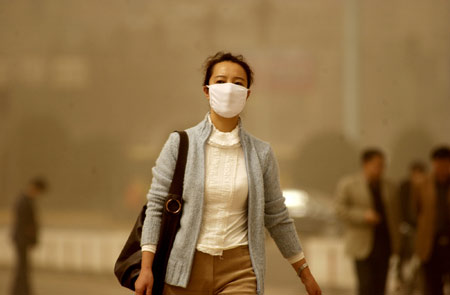 A woman walks amid sandstorm in Lanzhou, Northwest China's Gansu Province, March 28, 2007. Northern China was blanketed in dust on Saturday as the first sandstorm of the year struck the region, including the capital Beijing. [newsphoto]