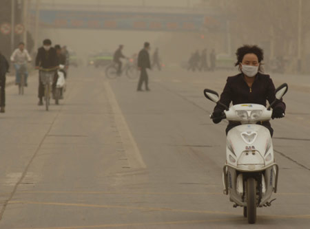 A motorcyclist makes her way amid sandstorm in Kashi, Northwest China's Xinjiang Uygur Autonomous Region, March 31, 2007. Northern China was blanketed in dust on Saturday as the first sandstorm of the year struck the region, including the capital Beijing.[Xinhua]