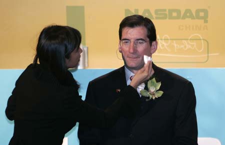 A woman prepares Nasdaq Chief Executive Bob Greifeld for an interview after the Nasdaq remote market open ceremony in Beijing April 3, 2007. Expected reforms to the U.S. Sarbanes-Oxley legislation on accounting would make it easier for Chinese firms to list in the United States, Greifeld said on Tuesday. 