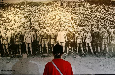 A visitor looks at a picture about the Red Army in a museum in Zunyi, Southwest China's Guizhou Province, June 29, 2006. [Yang Shuhuai/Sanxiang City Express] 