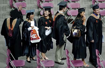 Virginia Tech graduate students look up to the crowd for family and friends while walking in prior to the graduate commencement ceremony at Cassell Coliseum on the campus of Virginia Tech in Blacksburg, Virginia May 11, 2007. On April 16 then Virginia Tech student Seung-Hui Cho killed 32 students and faculty before killing himself in the deadliest shooting in U.S. history . Some 3,600 seniors graduated from Virginia Tech. 