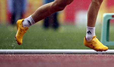 A player runs in rain during the 7th National Games for the Handicapped in Kunming, Southwest China's Yunnan Province, May 16, 2007. [Xinhua]