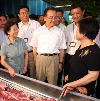 China's Premier Wen Jiabao talks with pork buyers at a supermarket in Xi'an, capital of North China's Shaanxi Province, May 27, 2007. Wen is on an inspection tour in the province to look into the supply and demand of pork, whose prices have risen sharply in a number of cities. [Xinhua]