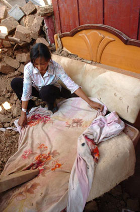 A Chinese woman Xue Wangfen clears the debris of her house following a strong earthquake in Ning'er, Southwest China's Yunnan Province, June 3, 2007. Xue Wangfen lost her 4-year-old child in the earthquake. The 6.4-magnitude quake struck the county seat of Ning'er shortly after 5:30 a.m. (2130 GMT Saturday), bringing down houses and killing at least three people, one a 4-year-old, and injuring 300, Xinhua reported. [Xinhua]