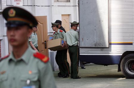 An armed policeman stands guard as others move boxes of examination papers for the upcoming National College Entrance Examination, or gaokao, into a test center in Beijing, June 5, 2007. Chinese education authorities have taken a set of measures to clean up the exam environment, including requiring test-takers to sign written pledges and increasing security checks at exam venues. But still cheating is on the rise. In last year's national college exam, about 3,000 students were caught cheating, China Daily reported last week.[newsphoto]