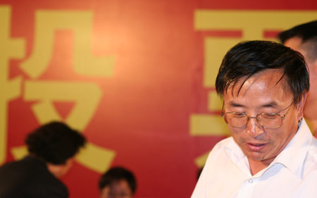 Ba Changrui, deputy leader for the Jiuxianqiao Sub-district Office, talks with voting workers after a voting on the housing demolition and compensation policy at Jiuxianqiao sub-district in Chaoyang District of Beijing, June 9, 2007. Some 3,711 families, about 57% of the 5,473 families, cast their votes on Saturday, with 2,451 votes for and 1,228 votes against the demolition and compensation plan. Thirty-two votes were invalid. 