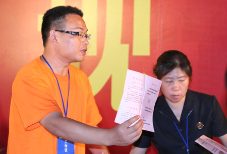 A residents' representative shows the ballot during the counting after a voting on the housing demolition and compensation policy at Jiuxianqiao sub-district in Chaoyang District of Beijing, June 9, 2007. Some 3,711 families, about 57% of the 5,473 families, cast their votes on Saturday, with 2,451 votes for and 1,228 votes against the demolition and compensation plan. Thirty-two votes were invalid. 