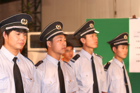 Chinese security men stand guard as the counting continues after a voting on the housing demolition and compensation policy at Jiuxianqiao sub-district in Chaoyang District of Beijing, June 9, 2007. Some 3,711 families, about 57% of the 5,473 families, cast their votes on Saturday, with 2,451 votes for and 1,228 votes against the demolition and compensation plan. Thirty-two votes were invalid. 