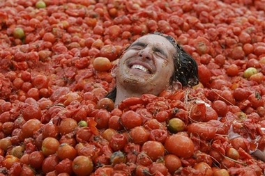 A participant lies in smashed tomatoes during the third annual tomato fight called 'tomatina' in Sutamarchan, 71 miles northeast of Bogota, Sunday, June 10, 2007. (AP Photo/Fernando Vergara) 