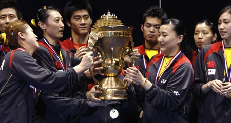The Chinese badminton squad hold the winners trophy after the final of the Sudirman Cup World Team Badminton Championships in Glasgow, Scotland, June 17, 2007.