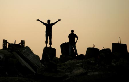 Palestinians stand at Gaza beach at sunset July 10, 2007. 