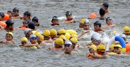 Participant swim across the Pearl River, China's third longest river, during an annual event in Guangzhou, South China's Guangdong Province July 15, 2007. Leaders of the southern Chinese city of Guangzhou led some 3700 residents in a 