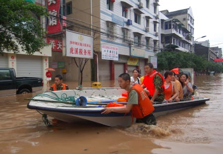 Chinese soldiers evacuate residents from a flooded neighbourhood after a heavy downpour in Southwest China's Chongqing Municipality, July 17, 2007. [Xinhua]