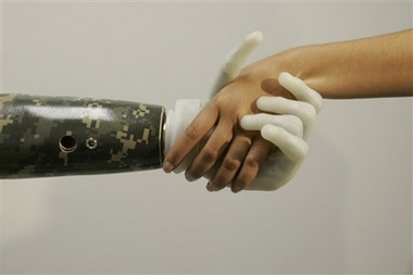 Iraq war veteran Sgt. Juan Arredondo, left, one of the first recipients of a bionic hand with independently moving fingers called the i-Limb, shakes a reporters hand during an interview Monday, July 23, 2007 in New York. Arredondo's bionic hand has finger 'joints' that flex and bend like natural fingers. Each finger has an individual motor powering it, enhancing dexterity and allowing patients to do activities they were unable to do with previous prosthetics, such as shaking another person's hand and naturally grasping around round objects such as door knobs, fishing rods, and computer mouse. (AP Photo/Mary Altaffer) 