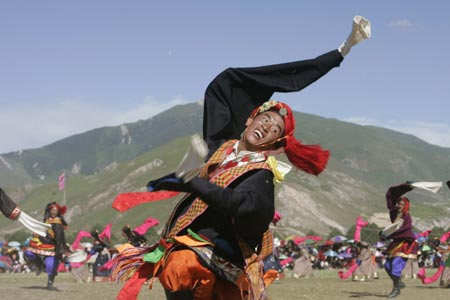 Tibetans perform a traditional dance during a cultural festival in Yushu, Northwest China's Qinghai Province July 27, 2007. The five-day arts festival includes folk performances, costume displays and horse racing, local media reported. [Reuters]