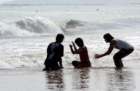 Visitors play at a beach as the tropical storm Wutip weakens to a tropical depression in Putian, East China’s Fujian Province August 9, 2007. Wutip, meaning 'butterfly', is set to unleash gales and rain in Fujian and neighboring Zhejiang province from late Thursday through to Friday, Xinhua News Agency reported. [Xinhua]