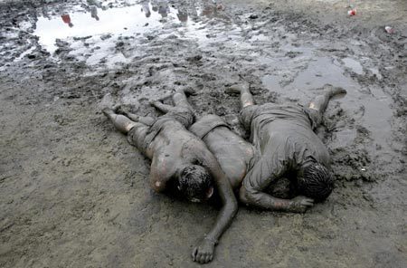 Revellers play in the mud during the Sziget Music Festival on an island in Danube, Budapest August 12, 2007. The annual non-stop festival lasts for a week. 