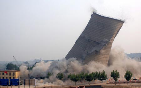 A cooling tower at the Datang Weihe Power Generation Company is imploded in Xianyang, North China's Shaanxi Province, August 15, 2007. China shut down small thermal power plants with an installed capacity totaling 6.95 million kilowatts in the first half of the year, completing about 70 percent of the pre-set goal in this regard in 2007, Xinhua News Agency reported. [Xinhua]