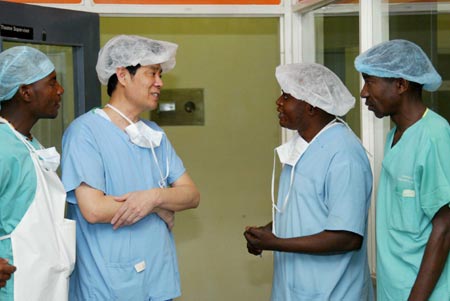 Chinese doctor Wu Weiguo (2nd L) talks with Zambia counterparts in Lusaka, Zambia, August 15, 2007. China now has 28 medical workers working at seven hospitals in Zambia in an effort to improve the local medical services. [Xinhua]