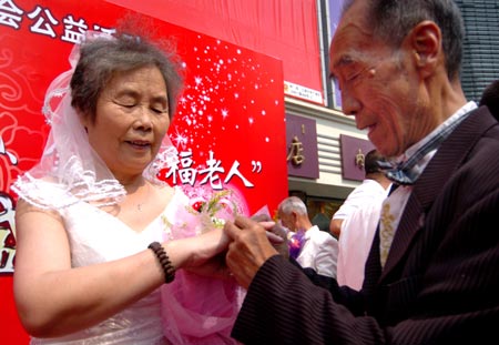 Eighty-year-old Li Wanhe puts a ring on his wife Chen Linfeng’s finger during a ceremony to celebrate Chinese’s Valentine's Day in Hohhot, North China’s Inner Mongolia Autonomous Region, August 19, 2007.[Xinhua]