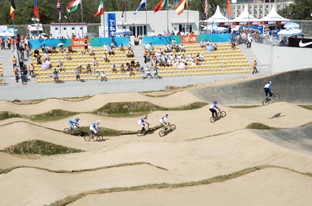 Competitors ride over the course during the UCI BMX Supercross World Cup at Laoshan Bicycle Moto Cross (BMX) venue in Beijing August 21, 2007.[Xinhua]